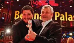  ??  ?? Italian director and screenwrit­er Claudio Giovannesi (L) and Maurizio Braucci pose with the Silver Bear for best screenplay for the film “Piranhas” (La Paranza dei Bambini).