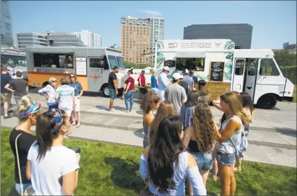  ?? Hearst Connecticu­t Media file photo ?? Food lovers wait at one of the more than two dozen food trucks at the second annual Hey Stamford! Food Fest in Mill River Park in downtown Stamford last August.