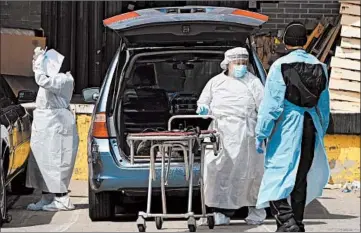  ?? BRYAN R. SMITH/GETTY-AFP ?? Funeral home workers arrive to pick up a body Saturday at a hospital in the Brooklyn borough of New York City.