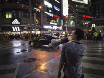  ?? CHRIS YOUNG/THE CANADIAN PRESS FILE PHOTO ?? An assistant director stands by as a stunt car drives down Yonge St. during the shooting of Suicide Squad, in May 2015. Will Smith said that even he was excited by seeing the Batmobile in action.