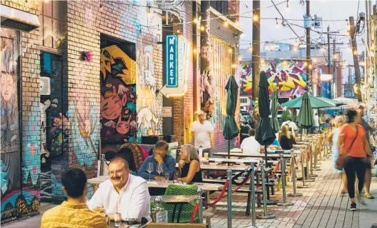  ?? JAMES STUKENBERG/THE NEW YORK TIMES PHOTOS ?? Patrons dine Aug. 5 in an alleyway in RiNo, an arts district made up of portions of five neighborho­ods in north Denver.