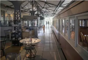  ?? — AFP photos ?? A kid runs past a converted train carriage at the Kruger Station in Skukuza, Kruger National Park.