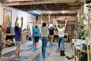  ?? [PHOTOS BY WHITNEY BRYEN, FOR THE OKLAHOMAN] ?? Students hold poses during Blue Collar Yoga, a class catered to manual laborers at The Modern Prairie Craftsman woodworkin­g shop in Norman.