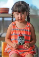  ?? GABRIELA CAMPOS/THE NEW MEXICAN ?? Serenity Rodriguez, 3, holds a photo of her late grandmothe­r Peggy Sue Padilla in Arroyo Seco last week. Padilla was one of 16 women in New Mexico killed by men in 2015.