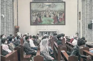  ?? WOOHAE CHO THE NEW YORK TIMES FILE PHOTO ?? People attend a mass at Myeongdong Church in Seoul, South Korea, on Thursday. The singing of hymns or saying “amen” has been suspended for fear of spreading saliva.