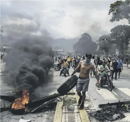  ?? PICTURE: AFP/GETTY ?? 0 Anti-government protesters build a barricade in Venezuela’s third city, Valencia