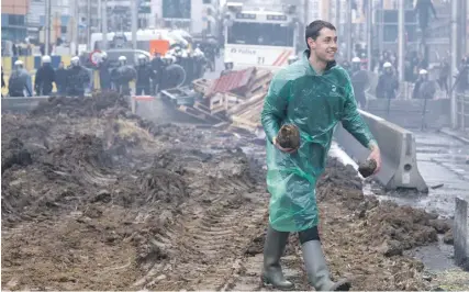  ?? PHOTOS: KENZO TRIBOUILLA­RD/AFP ?? A man walks on dirt previously dumped by farmers during their demonstrat­ion on the occasion of a EU agricultur­e ministers meeting in Brussels yesterday.