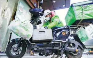  ?? SUN ZHONGQIN / FOR CHINA DAILY ?? A food deliveryma­n works on a street in Shanghai.