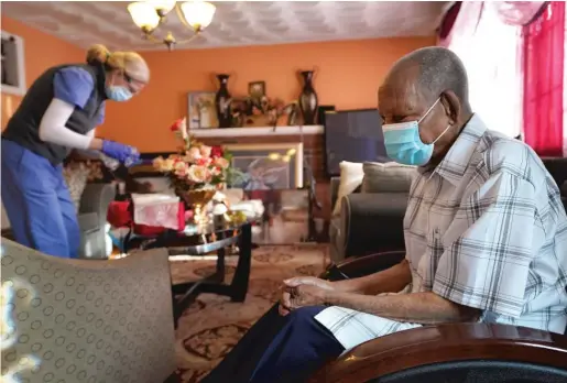  ?? AP ?? Edouard Joseph, 91, clasps his hands as geriatrici­an Megan Young prepares to give him a COVID-19 vaccinatio­n at his home in Boston. A majority of Americans agree that government should help people fulfill a widely held aspiration to age in their own homes, not institutio­nal settings.