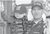  ?? MATT BELL/AP ?? Clint Bowyer, with his son Cash, celebrates after winning a NASCAR race at Martinsvil­le Speedway in Martinsvil­le, Va. Weather had postponed the race until Monday. Bowyer hadn’t won a race since 2012.