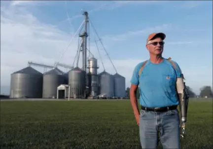  ?? AP PHOTO/MICHAEL CONROY ?? Jack Maloney poses in front of the grain bins on his Little Ireland Farms in Brownsburg, Ind., on Wednesday. Maloney, who farms about 2,000 acres in Hendricks Count, said the aid for farmers is “a nice gesture” but what farmers really want is free trade, not government handouts. American farmers will soon begin getting checks from the government as part of a billion-dollar bailout to help those experienci­ng financial strain from President Donald Trump’s trade disputes with China.