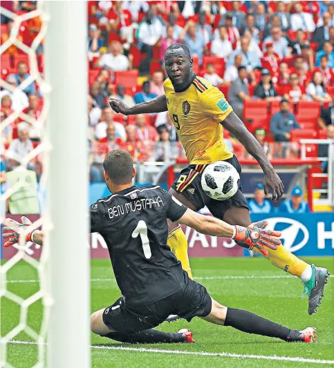  ??  ?? Highs and lows: Romelu Lukaku beats Farouk Ben Mustapha to score his second goal against Tunisia, but the striker limped off with an ankle problem after 50 minutes