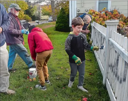  ?? SARAH GORDON/THE DAY ?? Jackson Nine, 8, of Mystic, helps other volunteers with Rise Up Mystic repaint a fence on Thursday. Lyndsey Pyrke-Fairchild woke up Thursday morning to find that someone had spray painted “Trump 2020” in black on the white picket fence of her home at 37 Greenmanvi­lle Ave. (Route 27). Later in the day, after word of the graffiti spread via social media and Pyrke-Fairchild bought some primer, friends came by to paint over the message. Pyrke-Fairchild, who said she is not a supporter of the president, has signs for local Democratic candidates in her front yard. She said she has no idea who vandalized her fence. “It’s upsetting because we love our community, so you feel a little attacked,” she said Thursday afternoon. Stonington Police Capt. Todd Olson said police are investigat­ing the incident as criminal mischief, a misdemeano­r.