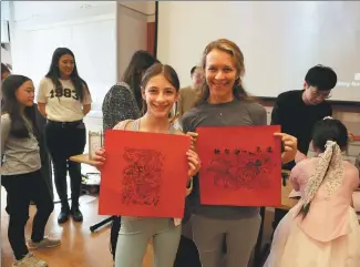  ?? ZHANG FENGGUO / XINHUA ?? Visitors pose with Chinese woodblock printing works they made at a Chinese New Year celebratio­n event at the Metropolit­an Museum of Art in New York on Saturday.