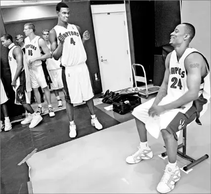  ?? PETER POWER/TORONTO STAR ?? Raptors’ Chris Bosh ( 4) has some fun teasing Morris Peterson during the club’s picture-taking session yesterday at the Air Canada Centre.