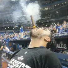  ?? JACK BOLAND/PNG FILES ?? Toronto Blue Jays backup catcher Dioner Navarro smokes a stogie after the Blue Jays swept the Texas Rangers with a victory in Game 3 of the ALDS in Toronto on Sunday. The Jays have been on a celebrator­y run since their road trip to Seattle Sept. 19.