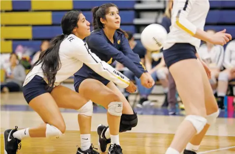  ??  ?? Santa Fe’s Taliyah Balladares, front, and Alyssa Sandoval try to return a serve from Capital during the first game of Tuesday’s match at Santa Fe High. The Demonettes won, securing second place in District 5-5A.