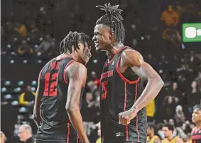  ?? Peter Aiken/Getty Images ?? UH’s Tramon Mark, left, and Jarace Walker celebrate Thursday’s victory. Walker scored 15 points and rallied UH for the second game in a row.