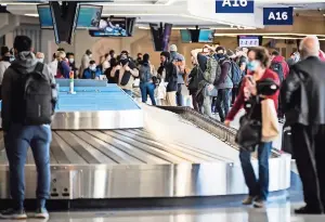  ??  ?? Viajeros esperan su equipaje en el aeropuerto dallas/fort Worth el 23 de diciembre