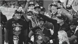  ?? MARK J. TERRILL/ASSOCIATED PRESS ?? The Los Angeles Lakers' Rajon Rondo holds the trophy as he celebrates with teammates after they defeated the Miami Heat 106-93 Sunday in Game 6 of the NBA Finals.