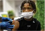  ?? ALYSSA POINTER/ALYSSA.POINTER@AJC.COM ?? G.P. Babb Middle School student Isiah Osby gets a bandage Tuesday after receiving the Pfizer COVID-19 vaccine at G.P. Babb Middle School in Forest Park.