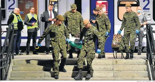  ?? MACIEJ KULCZYNSKI / EFE ?? Soldados polacos portan ayer una camilla con un militar ucraniano herido para que sea tratado en Wroclaw (Polonia).