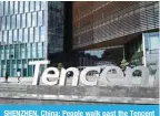  ?? ?? SHENZHEN, China: People walk past the Tencent headquarte­rs in Shenzhen in China’s southern Guangdong province. – AFP