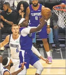  ?? Brian van der Brug Los Angeles Times ?? CLIPPERS guard Reggie Jackson drives to the basket past Kristaps Porzingis of Dallas en route to a 31-point night.