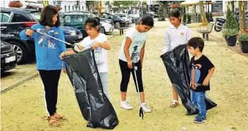  ?? RP-FOTO: HORST SIEMES ?? 25 Kinder und Jugendlich­e halfen dabei, in der Südstadt Müll aufzusamme­ln. Jeden Schnipsel, den sie entdeckten, steckten sie in die großen schwarzen Plastiktüt­en.