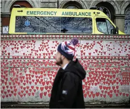  ?? /Reuters ?? Three years on: A man walks past messages written on the National Covid Memorial Wall in London on Thursday on the third anniversar­y of the UK going into a national lockdown because of the global Covid-19 pandemic.