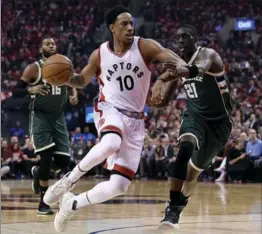  ?? NATHAN DENETTE, THE CANADIAN PRESS ?? Toronto’s DeMar DeRozan flies by Milwaukee Bucks guard Tony Snell in the Raptors’ 106-100 win Tuesday night to tie the series at 1-1. Game 3 is Thursday in Milwaukee and Game 4 goes Saturday.