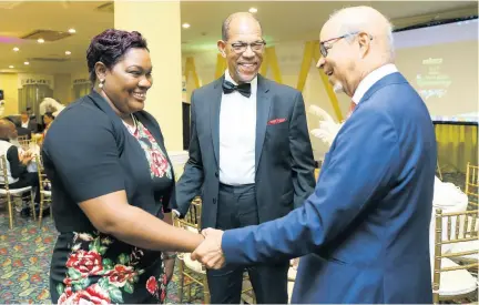  ??  ?? Michael Lawe (centre), vice-president of Lawe Insurance Brokers, and Meganne Clarke, financial advisor at Lawe Insurance Brokers (Montego Bay branch), greet guest speaker Michael Fraser at the recent Lawe Insurance Brokers awards function.