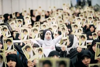  ??  ?? MUJERES iraníes afectas al régimen sostienen retratos del ayatola Khameini durante un mitin en Teherán donde el líder iraní menospreci­ó la reunión de Viena.