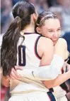  ?? CLOE POISSON/SPECIAL TO THE COURANT ?? The Huskies’ Paige Bueckers, right, hugs Nika Muhl after Muhl fouled out late in their Big East Tournament championsh­ip against Georgetown on March 10.