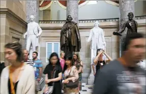  ?? Mark Wilson/Getty Images ?? Tourists walk past a bronze statue of Confederat­e president Jefferson Davis that stands inside Statuary Hall at the U.S. Capitol on Thursday in Washington. Virginia Governor Terry McAuliffe said he would like to remove all Confederat­e statues in the...