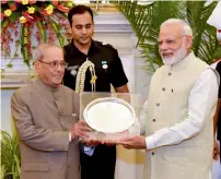  ?? PTI file ?? Prime Minister Narendra Modi presents a memento to President Pranab Mukherjee at the farewell hosted by him for the President at Hyderabad House in New Delhi. —