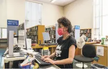  ?? Nick Otto / Special to The Chronicle ?? Alison Heyman works at the Oakland Public Library. Alameda County is among the first to resume some library services.