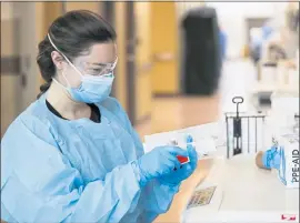  ?? NATHAN PAPES — THE SPRINGFIEL­D NEWS-LEADER VIA AP ?? An employee in the CoxHealth Emergency Department in Springfiel­d, Mo., dons personal protective equipment to treat patients with COVID-19 on Friday.