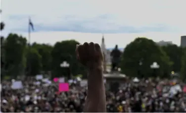  ?? The Denver Post Aaron Ontiveroz, ?? A man raises his fist Monday to honor black lives during a protest after the death of George Floyd Ð the Minnesota man, who was killed by a Minneapoli­s police officer this week, while being detained.