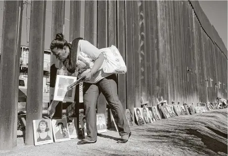  ?? San Antonio Express-News photos ?? Nohemy Alvares spreads photograph­s of disappeare­d family members against the wall along the Mexico and Arizona border in Nogales, Sonora, Mexico. Her son, Gilver, is among the missing. “He had dreams of owning a car and house.”