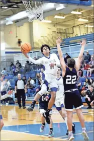  ?? Barbara hall ?? Gordon Central junior guard Jamori George twists for a layup shot against Unity Christian Saturday night in the Warriors’ gym.