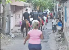  ??  ?? Agentes de la Policía Montada ingresan a uno de los pasillos del barrio ante las miradas de vecinos.