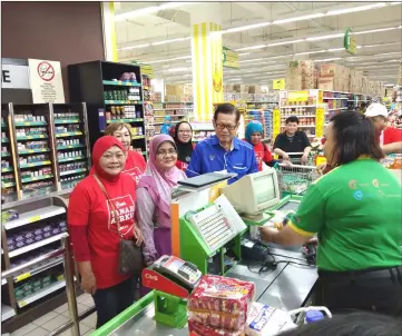  ??  ?? Lee (third left) accompanie­s a recipient to the payment counter at Giant Supermarke­t while members of NRC look on.