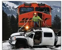  ?? AP/The Missoulian/KURT WILSON ?? A railroad official checks out the damage Tuesday after a train hit this pickup west of Alberton, Mont., and pushed it about half a mile along the tracks before it could stop. The pickup driverwas injured.