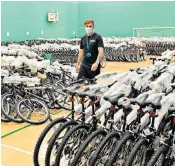  ??  ?? Chris Colgan, of the University of Bolton, inspects 1,000 bicycles it has bought for students