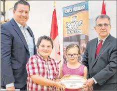  ?? SUBMITTED PHOTO ?? Kensington-Malpeque MLA Matthew MacKay, left, and Environmen­t Minister Richard Brown present students P.J. Paugh and Taylor Beamish of Queen Elizabeth Elementary School with a P.E.I. Environmen­t Award Monday.