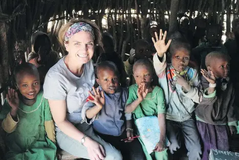 ?? KEN DONOHUE ?? Carrie, a teacher by profession, spends time with children at a Maasai school.