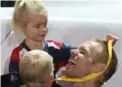  ?? STEVE RUSSELL/TORONTO STAR ?? Children of the U.K.’s Mark Omrod play with their father’s silver medal, which he won for one-minute indoor rowing.