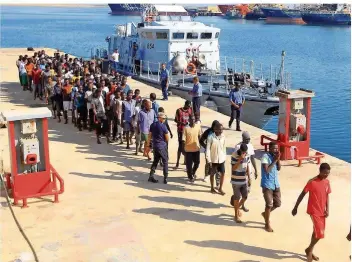  ?? FOTO: TURKIA/AFP ?? Solche Bilder aus Libyen gibt es fast täglich: Afrikanisc­he Flüchtling­e, die aus dem Mittelmeer gerettet wurden, gehen in Tripolis an Land. Auch um ihre Zukunft ging es bei dem Migrations­gipfel in Paris.