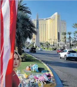  ?? MARK RALSTON/GETTY ?? An American flag is part of a makeshift memorial outside the site of the mass shooting Sunday night in Las Vegas. Investigat­ors have yet to find a motive for the massacre.